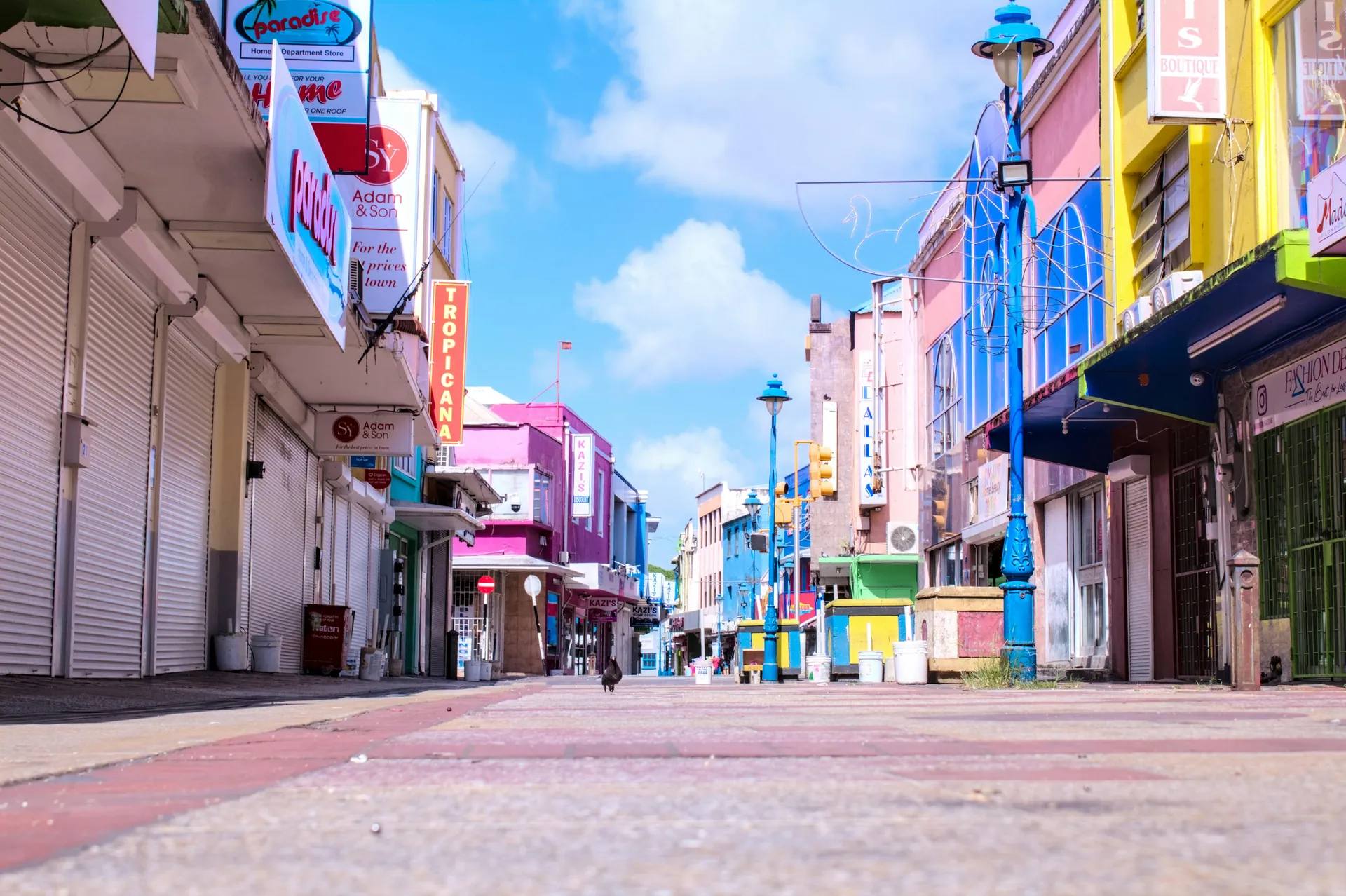 Vibrant downtown street in Bridgetown, Barbados with colorful buildings and a clear blue sky.